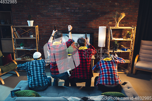 Image of Group of friends watching TV, sport match together. Emotional fans cheering for favourite team, watching on exciting game. Concept of friendship, leisure activity, emotions