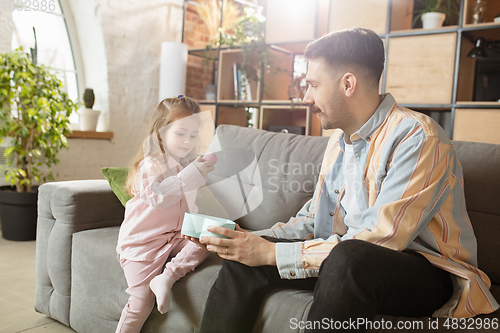 Image of Happy father and little cute daughter at home. Family time, togehterness, parenting and happy childhood concept. Weekend with sincere emotions.