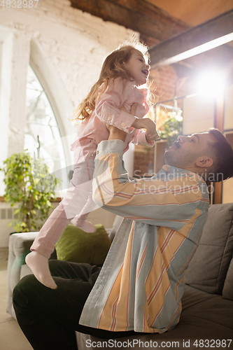 Image of Smiling. Happy father and little cute daughter at home. Family time, togehterness, parenting and happy childhood concept. Weekend with sincere emotions.