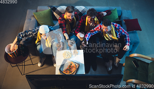 Image of Group of friends watching TV, sport match together. Emotional fans cheering for favourite team. Top view. Concept of friendship, leisure activity, emotions