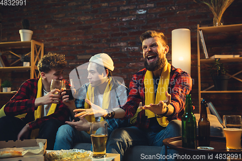 Image of Group of friends watching TV, sport match together. Emotional fans cheering for favourite team, watching on exciting game. Concept of friendship, leisure activity, emotions