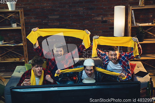 Image of Group of friends watching TV, sport match together. Emotional fans cheering for favourite team, watching on exciting game. Concept of friendship, leisure activity, emotions