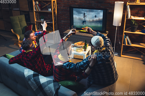 Image of Group of friends watching TV, sport match together. Emotional fans cheering for favourite team, watching on exciting game. Concept of friendship, leisure activity, emotions