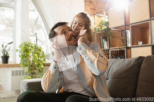 Image of Happy father and little cute daughter at home. Family time, togehterness, parenting and happy childhood concept. Weekend with sincere emotions.