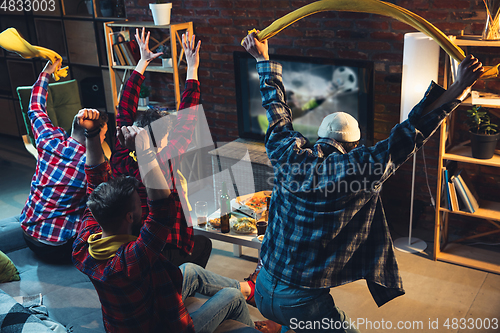 Image of Group of friends watching TV, sport match together. Emotional fans cheering for favourite team, watching on exciting game. Concept of friendship, leisure activity, emotions