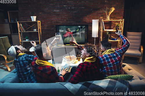 Image of Group of friends watching TV, sport match together. Emotional fans cheering for favourite team, watching on exciting game. Concept of friendship, leisure activity, emotions