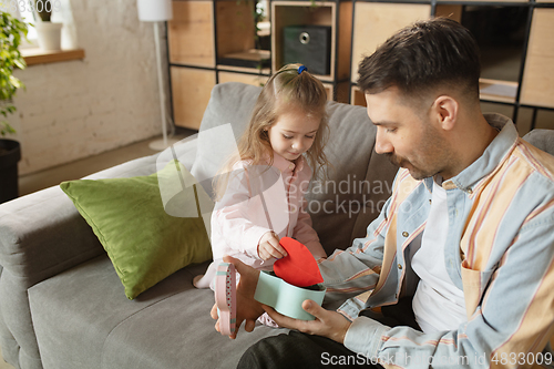 Image of Happy father and little cute daughter at home. Family time, togehterness, parenting and happy childhood concept. Weekend with sincere emotions.