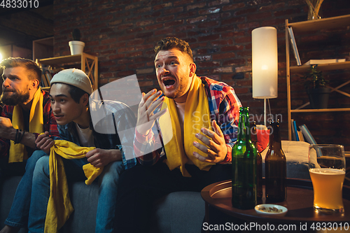 Image of Group of friends watching TV, sport match together. Emotional fans cheering for favourite team, watching on exciting game. Concept of friendship, leisure activity, emotions