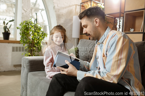 Image of Happy father and little cute daughter at home. Family time, togehterness, parenting and happy childhood concept. Weekend with sincere emotions.