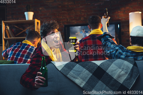 Image of Group of friends watching TV, sport match together. Emotional man cheering for favourite team, celebrating successful betting. Concept of friendship, leisure activity, emotions