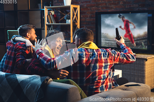 Image of Group of friends watching TV, sport match together. Emotional fans cheering for favourite team, watching on exciting game. Concept of friendship, leisure activity, emotions