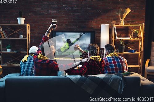 Image of Group of friends watching TV, sport match together. Emotional fans cheering for favourite team, watching on exciting game. Concept of friendship, leisure activity, emotions