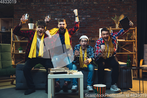 Image of Group of friends watching TV, sport match together. Emotional fans cheering for favourite team, watching on exciting game. Concept of friendship, leisure activity, emotions