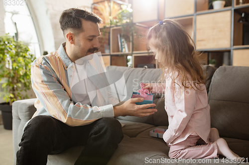 Image of Happy father and little cute daughter at home. Family time, togehterness, parenting and happy childhood concept. Weekend with sincere emotions.