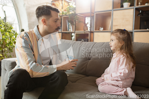 Image of Happy father and little cute daughter at home. Family time, togehterness, parenting and happy childhood concept. Weekend with sincere emotions.