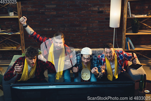 Image of Group of friends watching TV, sport match together. Emotional fans cheering for favourite team, watching on exciting game. Concept of friendship, leisure activity, emotions