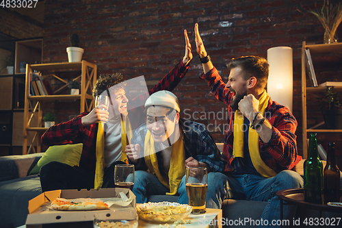 Image of Group of friends watching TV, sport match together. Emotional fans cheering for favourite team, watching on exciting game. Concept of friendship, leisure activity, emotions