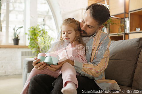 Image of Happy father and little cute daughter at home. Family time, togehterness, parenting and happy childhood concept. Weekend with sincere emotions.