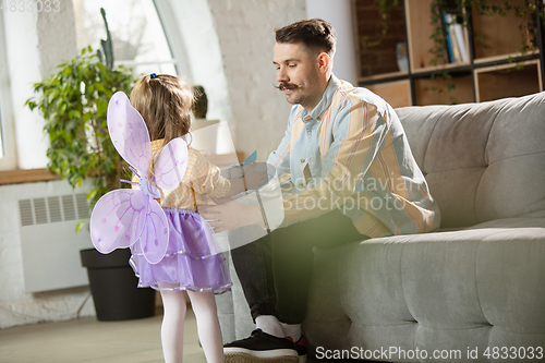 Image of Happy father and little cute daughter at home. Family time, togehterness, parenting and happy childhood concept. Weekend with sincere emotions.