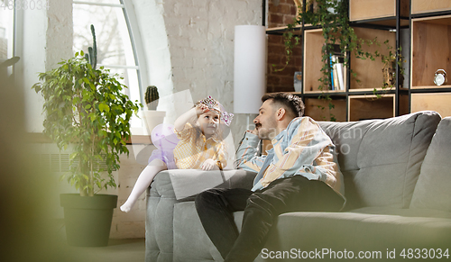 Image of Happy father and little cute daughter at home. Family time, togehterness, parenting and happy childhood concept. Weekend with sincere emotions.