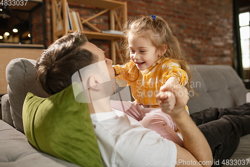 Image of Happy father and little cute daughter at home. Family time, togehterness, parenting and happy childhood concept. Weekend with sincere emotions.