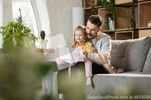 Image of Happy father and little cute daughter at home. Family time, togehterness, parenting and happy childhood concept. Weekend with sincere emotions.