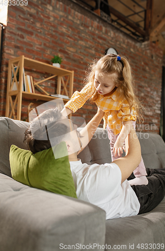 Image of Happy father and little cute daughter at home. Family time, togehterness, parenting and happy childhood concept. Weekend with sincere emotions.