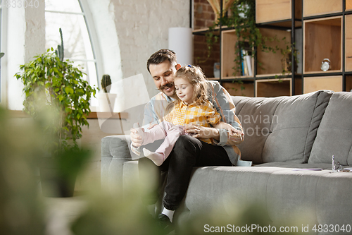 Image of Happy father and little cute daughter at home. Family time, togehterness, parenting and happy childhood concept. Weekend with sincere emotions.