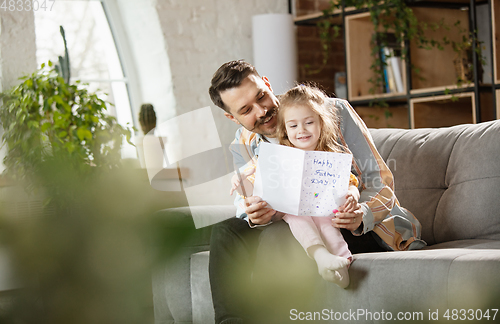 Image of Happy father and little cute daughter at home. Family time, togehterness, parenting and happy childhood concept. Weekend with sincere emotions.