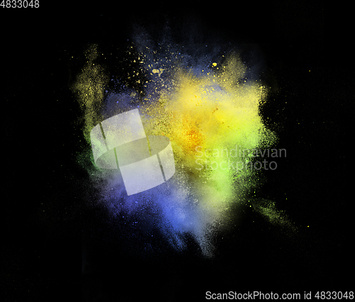 Image of Explosion of colored, fluid and neoned powder on black studio background with copyspace