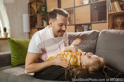 Image of Happy father and little cute daughter at home. Family time, togehterness, parenting and happy childhood concept. Weekend with sincere emotions.