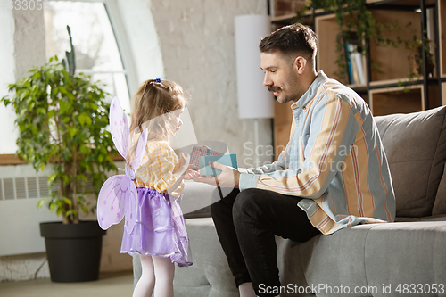 Image of Happy father and little cute daughter at home. Family time, togehterness, parenting and happy childhood concept. Weekend with sincere emotions.