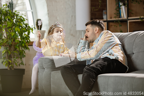 Image of Happy father and little cute daughter at home. Family time, togehterness, parenting and happy childhood concept. Weekend with sincere emotions.