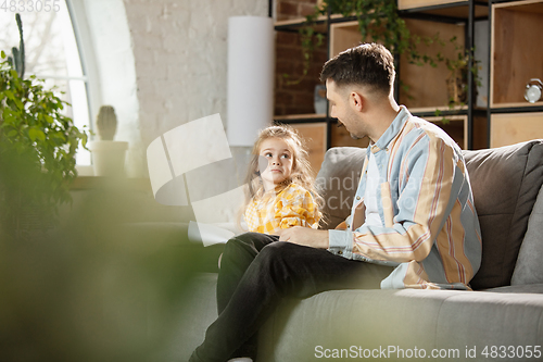 Image of Happy father and little cute daughter at home. Family time, togehterness, parenting and happy childhood concept. Weekend with sincere emotions.