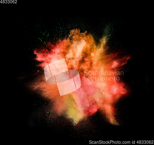 Image of Explosion of colored, fluid and neoned powder on black studio background with copyspace