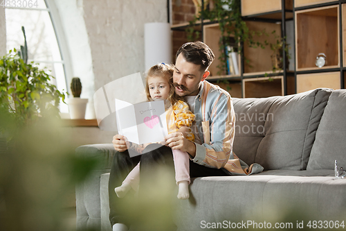 Image of Happy father and little cute daughter at home. Family time, togehterness, parenting and happy childhood concept. Weekend with sincere emotions.