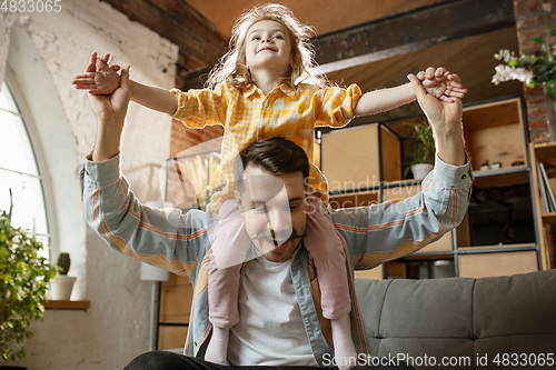 Image of Happy father and little cute daughter at home. Family time, togehterness, parenting and happy childhood concept. Weekend with sincere emotions.