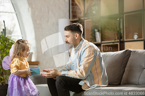 Image of Happy father and little cute daughter at home. Family time, togehterness, parenting and happy childhood concept. Weekend with sincere emotions.