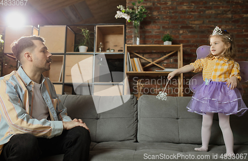 Image of Happy father and little cute daughter at home. Family time, togehterness, parenting and happy childhood concept. Weekend with sincere emotions.