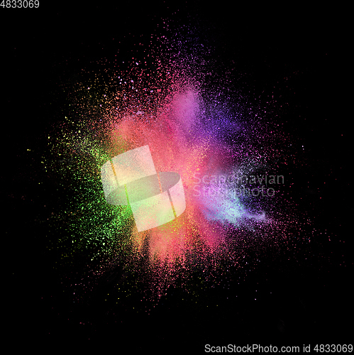 Image of Explosion of colored, fluid and neoned powder on black studio background with copyspace