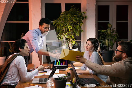 Image of Colleagues working together in modern office using devices and gadgets during creative meeting