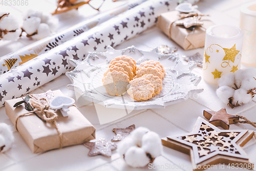 Image of Christmas time, homemade cookies with ornaments and winter decorations in white