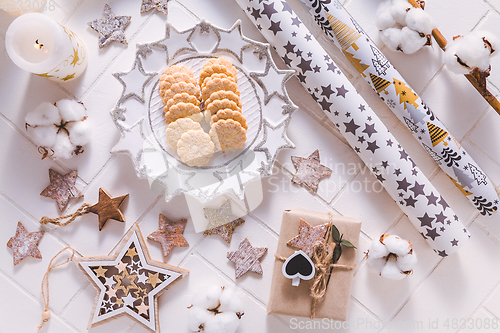 Image of Christmas time, homemade cookies with ornaments and winter decorations in white