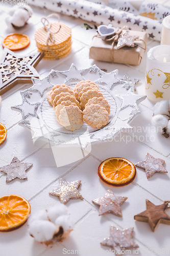 Image of Christmas time, homemade cookies with ornaments and winter decorations in white