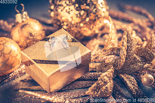 Image of Christmas ornaments with small present in golden tones