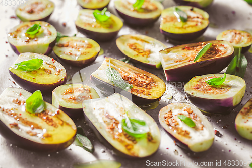 Image of Small raw eggplants prepared for baking on baking sheet