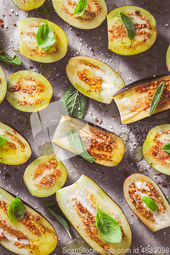 Image of Small raw eggplants prepared for baking on baking sheet