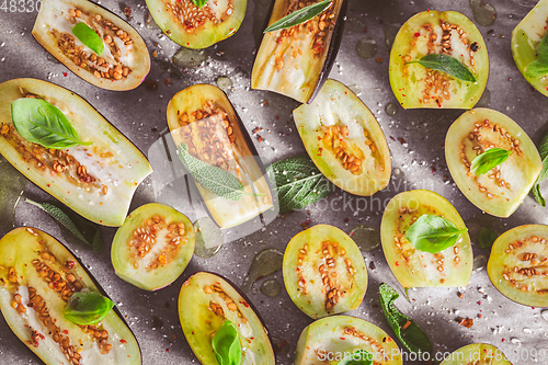 Image of Small raw eggplants prepared for baking on baking sheet