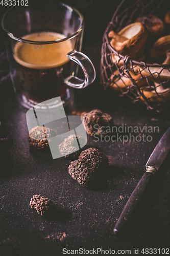 Image of Black truffle on dark kitchen table with black coffee and mushrooms 