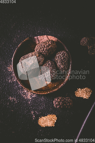 Image of Black truffle in bowl on dark background